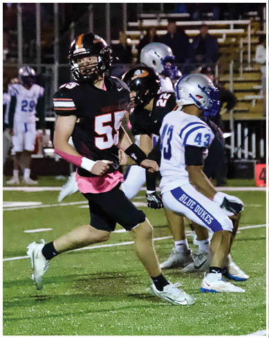 A football player wearing a blue and red jersey. Description generated by AI