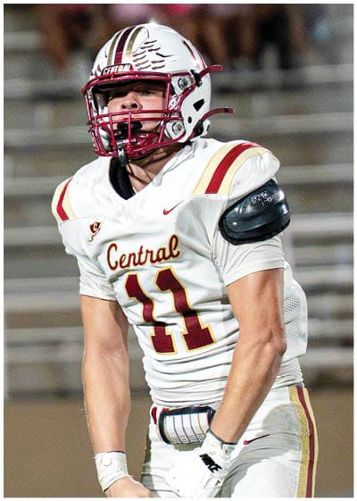 A person wearing a white football uniform with the word Central and the number 11 on the jersey is clenching their fists in a celebratory or intense gesture. Description generated by AI