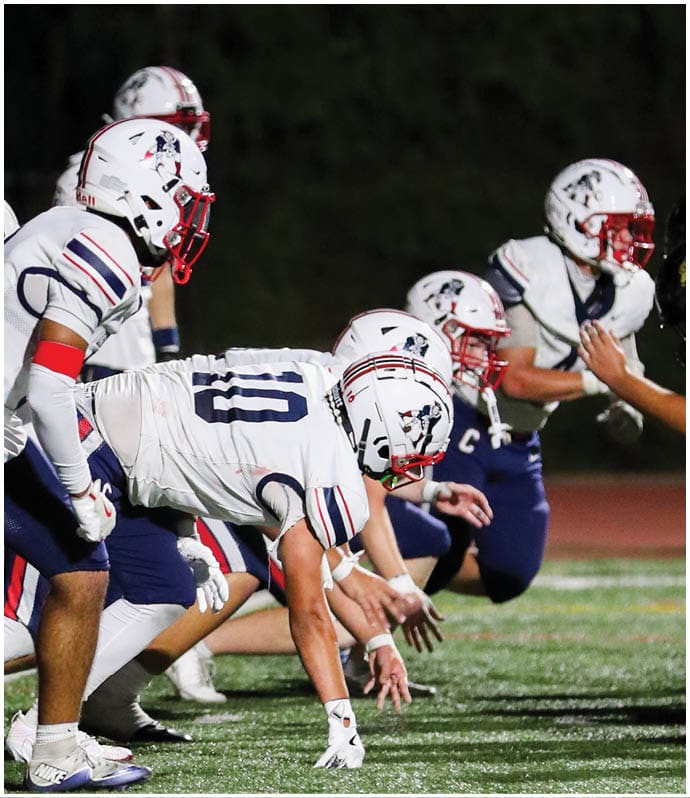 A group of football players wearing black and white uniforms. Description generated by AI