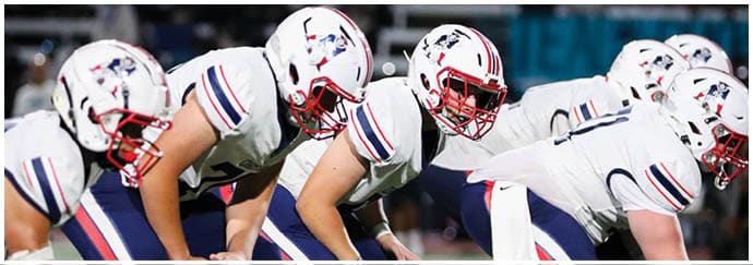 A group of football players on a field. Description generated by AI