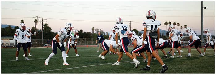 A group of football players on a field. Description generated by AI