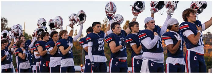 A group of football players on a field. Description generated by AI