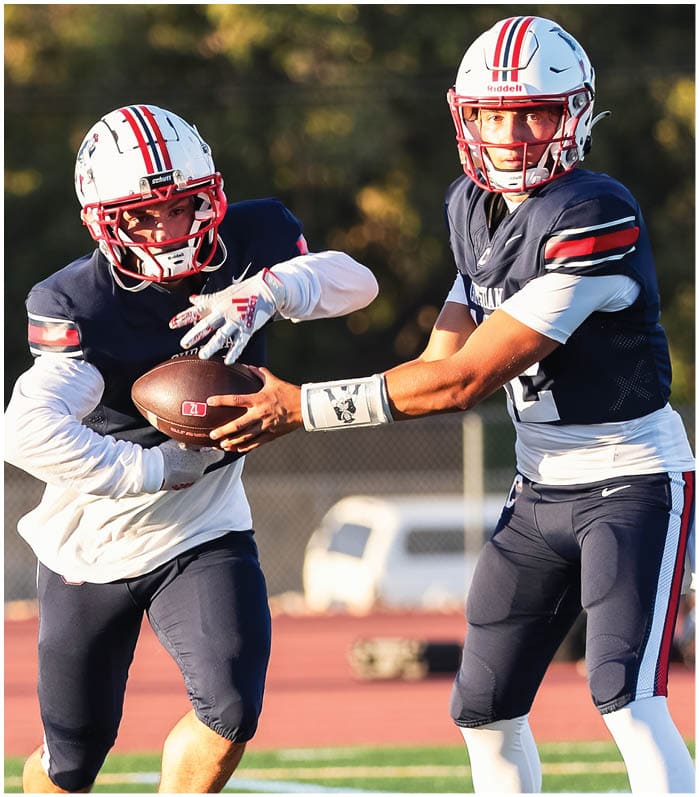 A group of football players wearing black and white uniforms. Description generated by AI