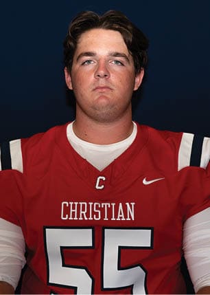 A young man wearing a white and black jersey with the number 14 on it. Description generated by AI