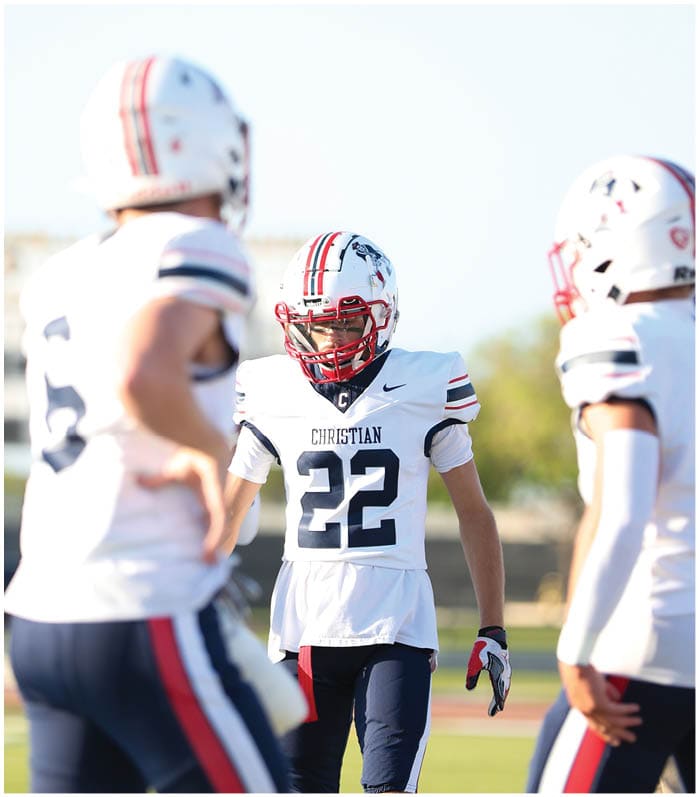 A group of football players wearing black and white uniforms. Description generated by AI