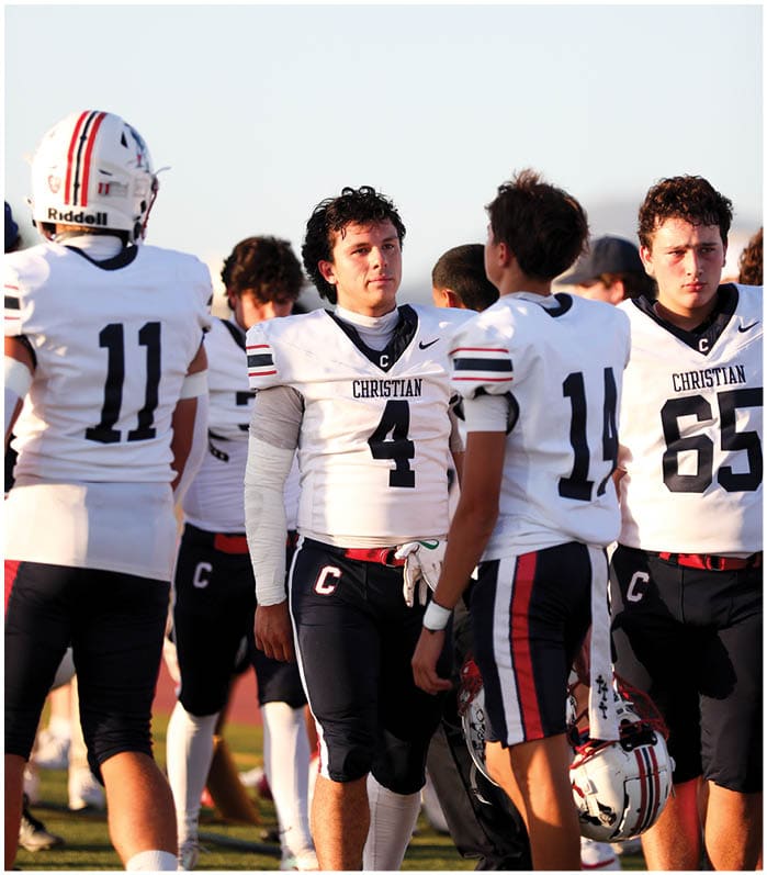 A group of football players wearing black and white uniforms. Description generated by AI