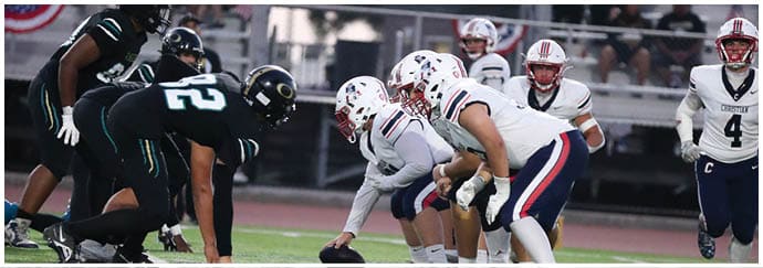 A group of football players on a field. Description generated by AI