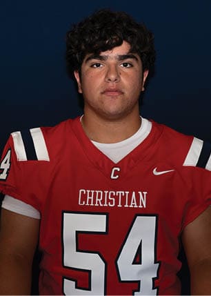 A young man wearing a white and black jersey with the number 14 on it. Description generated by AI