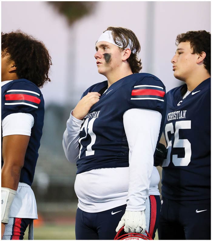 A group of football players wearing black and white uniforms. Description generated by AI