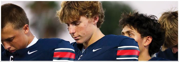 A group of football players on a field. Description generated by AI