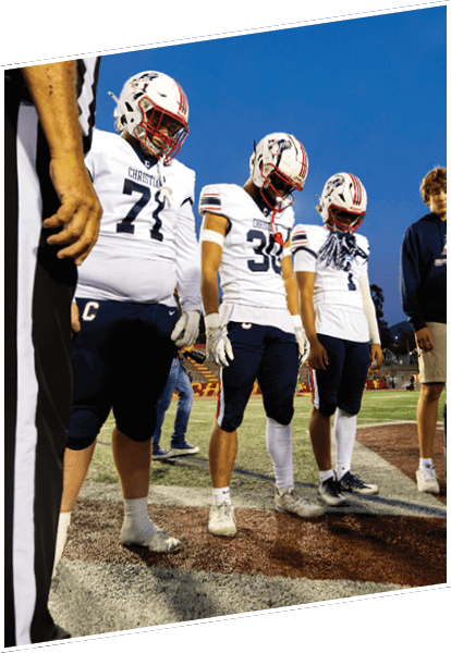 Three men wearing green and white uniforms are standing on a field. Description generated by AI