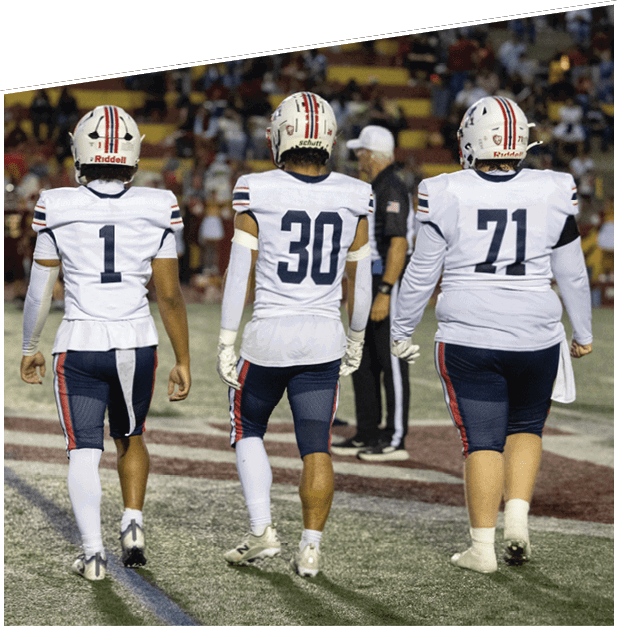 Three men wearing green and white uniforms are standing on a field. Description generated by AI