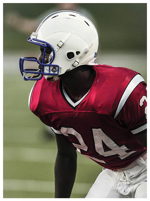 A football player wearing a helmet and jersey with the number 24. Description generated by AI