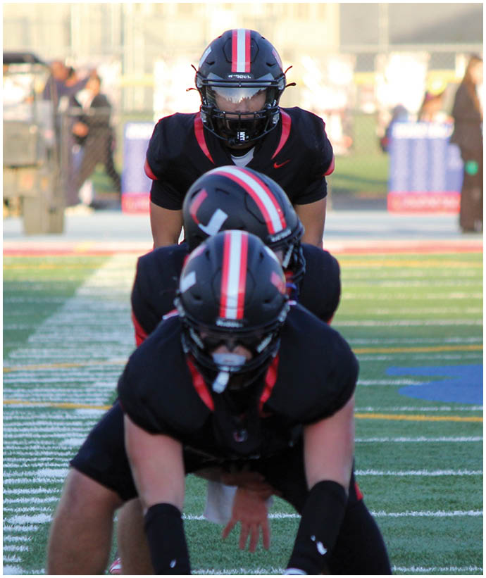 A group of football players wearing black and white uniforms. Description generated by AI