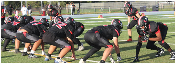 A group of football players on a field. Description generated by AI