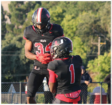 A football player wearing a blue and red jersey. Description generated by AI