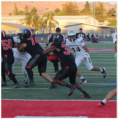 A football game is taking place with a group of men on the field. Description generated by AI