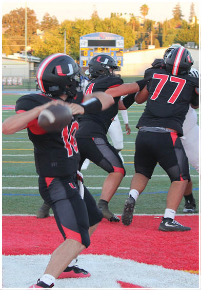 A football player wearing a blue and red jersey. Description generated by AI