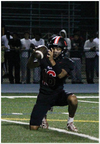 A football player wearing a blue and red jersey. Description generated by AI