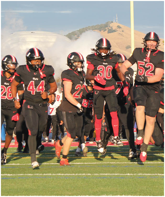 A group of football players wearing black and white uniforms. Description generated by AI