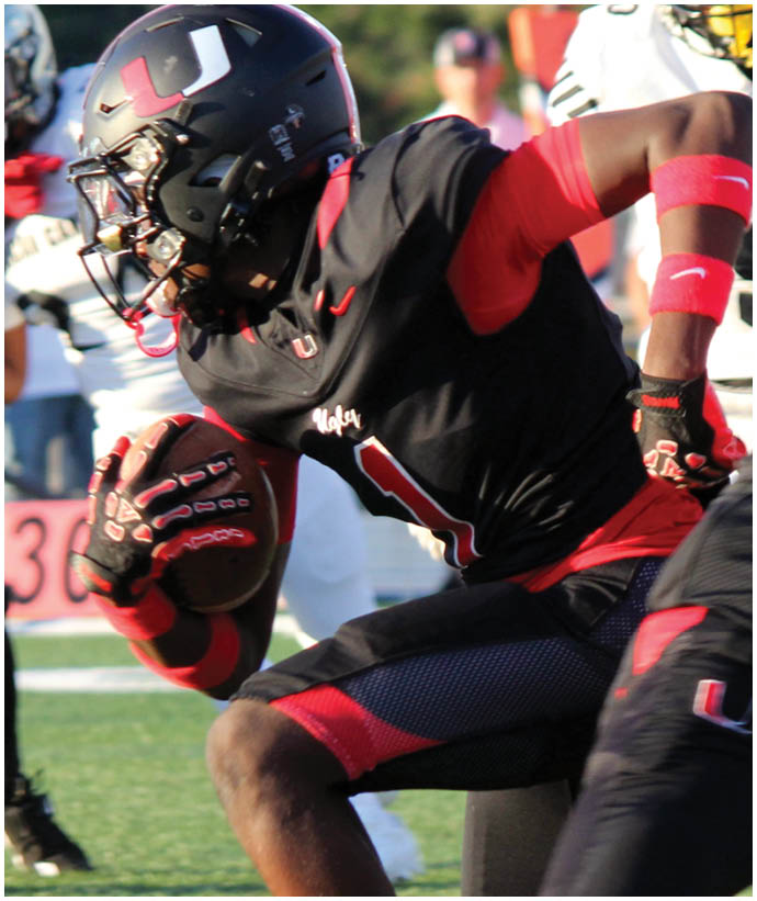 A group of football players wearing black and white uniforms. Description generated by AI