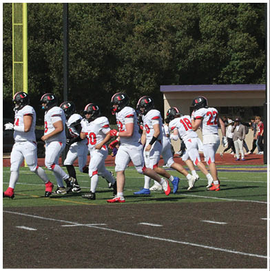 A football game is taking place with a group of men on the field. Description generated by AI