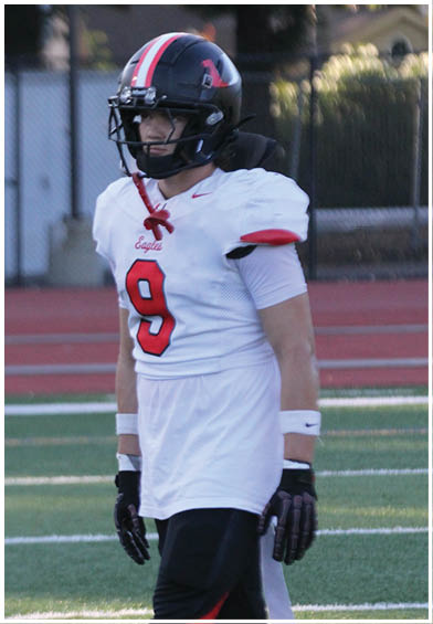 A football player wearing a blue and red jersey. Description generated by AI