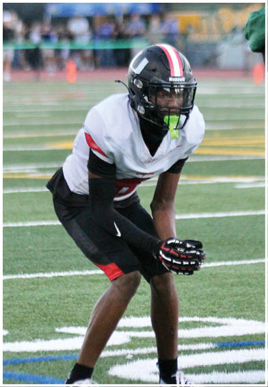 A football player wearing a blue and red jersey. Description generated by AI