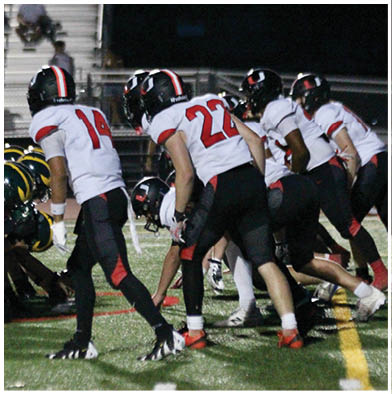 A football game is taking place with a group of men on the field. Description generated by AI