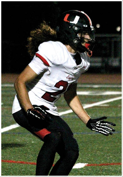 A football player wearing a blue and red jersey. Description generated by AI