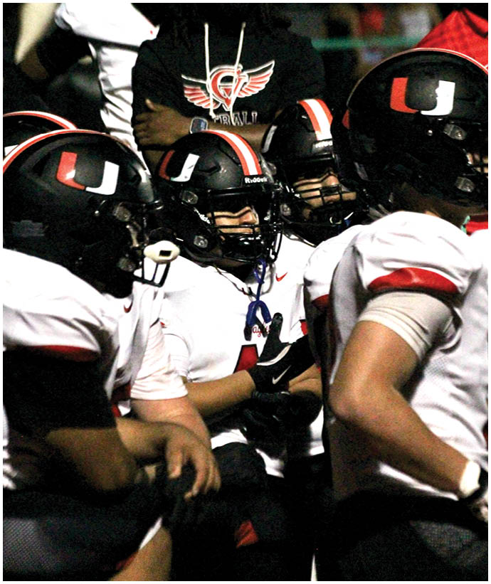 A group of football players wearing black and white uniforms. Description generated by AI