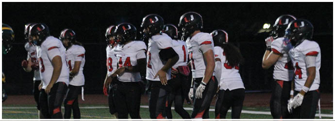 A group of football players on a field. Description generated by AI
