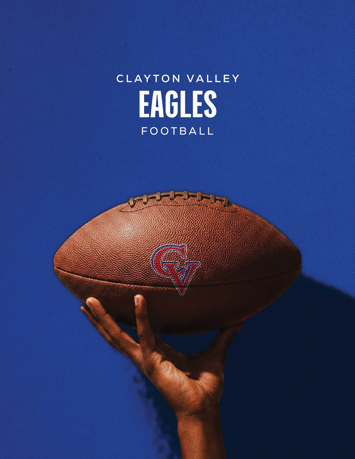 A hand is holding a football with a Clayton Valley Eagles logo against a solid blue background with the text Clayton Valley Eagles Football above. Description generated by AI