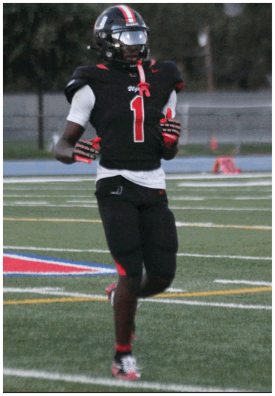 A football player wearing a blue and red jersey. Description generated by AI