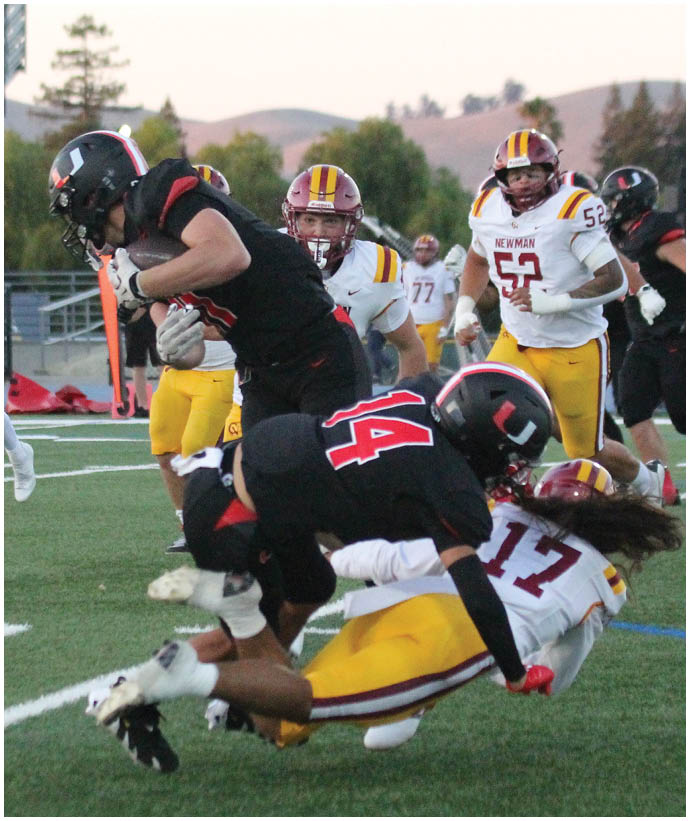 A group of football players wearing black and white uniforms. Description generated by AI
