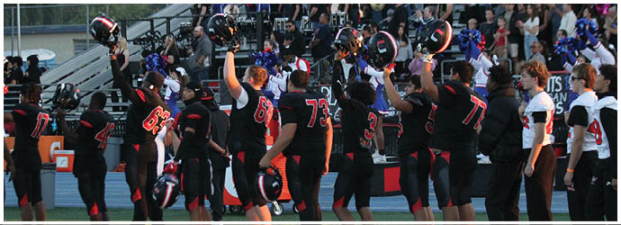 A group of football players on a field. Description generated by AI