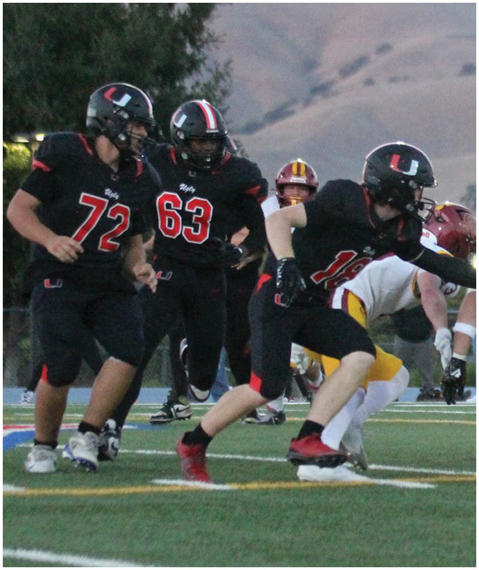 A group of football players wearing black and white uniforms. Description generated by AI