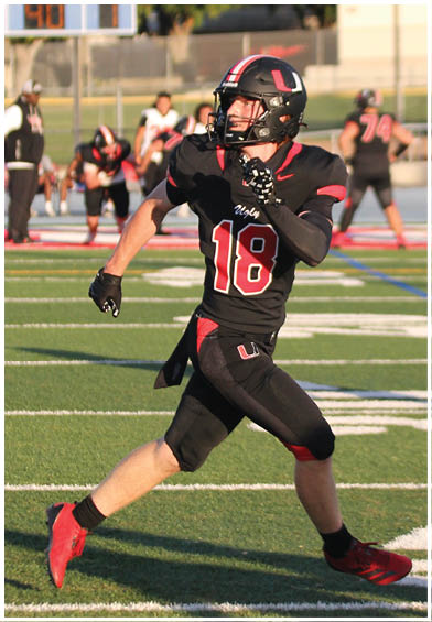 A football player wearing a blue and red jersey. Description generated by AI