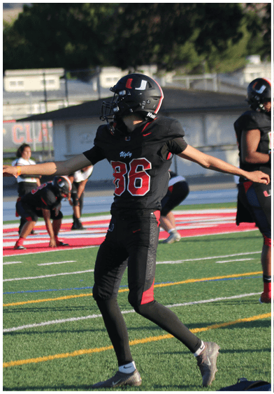 A football player wearing a blue and red jersey. Description generated by AI