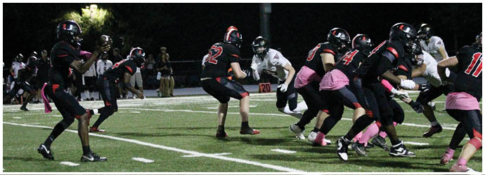 A group of football players on a field. Description generated by AI