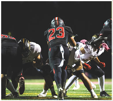 A football player wearing a blue and red jersey. Description generated by AI