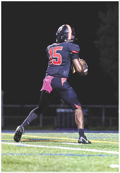 A football player wearing a blue and red jersey. Description generated by AI