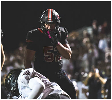 A football player wearing a blue and red jersey. Description generated by AI