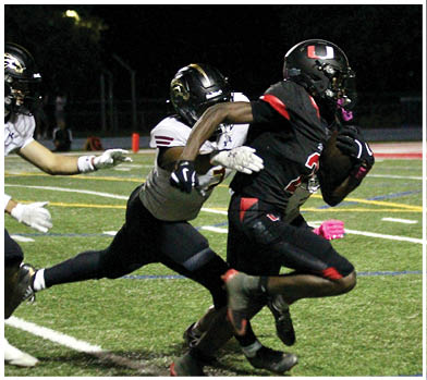 A football player wearing a blue and red jersey. Description generated by AI