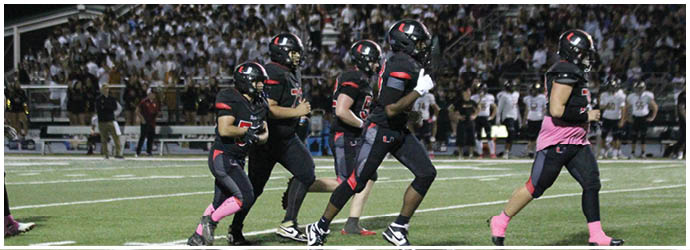 A group of football players on a field. Description generated by AI