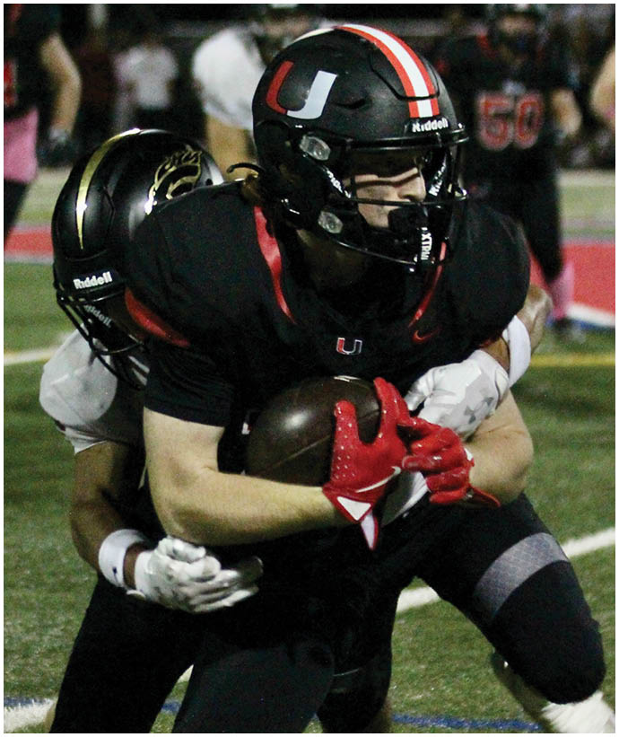 A group of football players wearing black and white uniforms. Description generated by AI