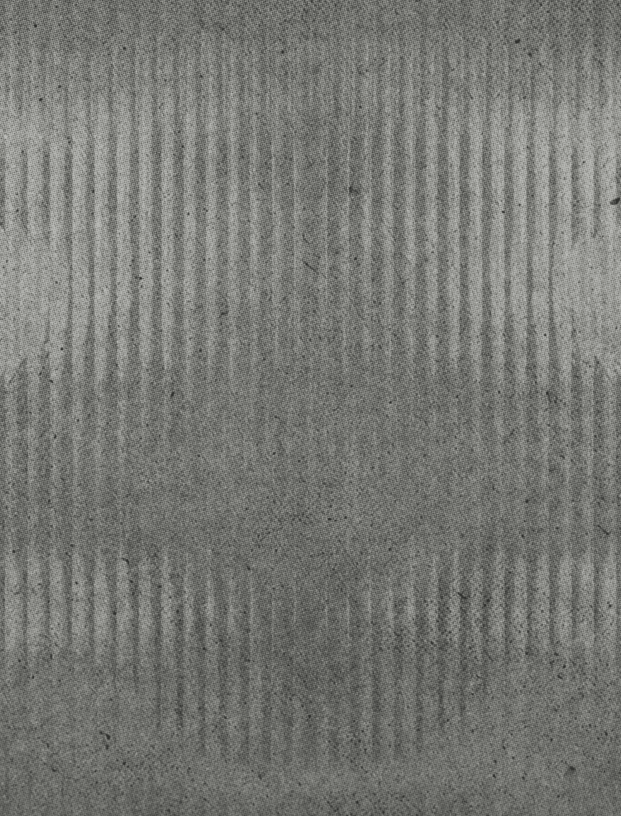 A dark textured surface with vertical ridges creating a subtle pattern. Descripci n generada con IA
