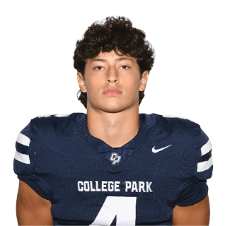 A person with curly hair wearing a navy blue football jersey with the number 4 and the words College Park stands facing forward against a plain background. Descripci n generada con IA