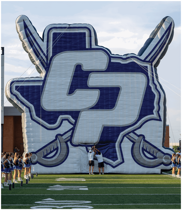 A close-up of a large inflatable object with bold blue and white letters “CP" against a sky background. Descripci n generada con IA