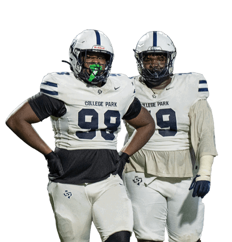 Two people wearing white football uniforms with helmets stand on a field, one with hands on hips and the other with arms relaxed. Descripci n generada con IA